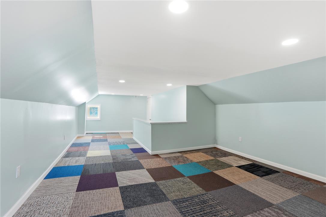 6271 Batman Road Zionsville, PA 18092 - Photo 60 of 100 A vibrant, multi-hued carpet flooring defines this versatile attic space, perfect for creative endeavors.