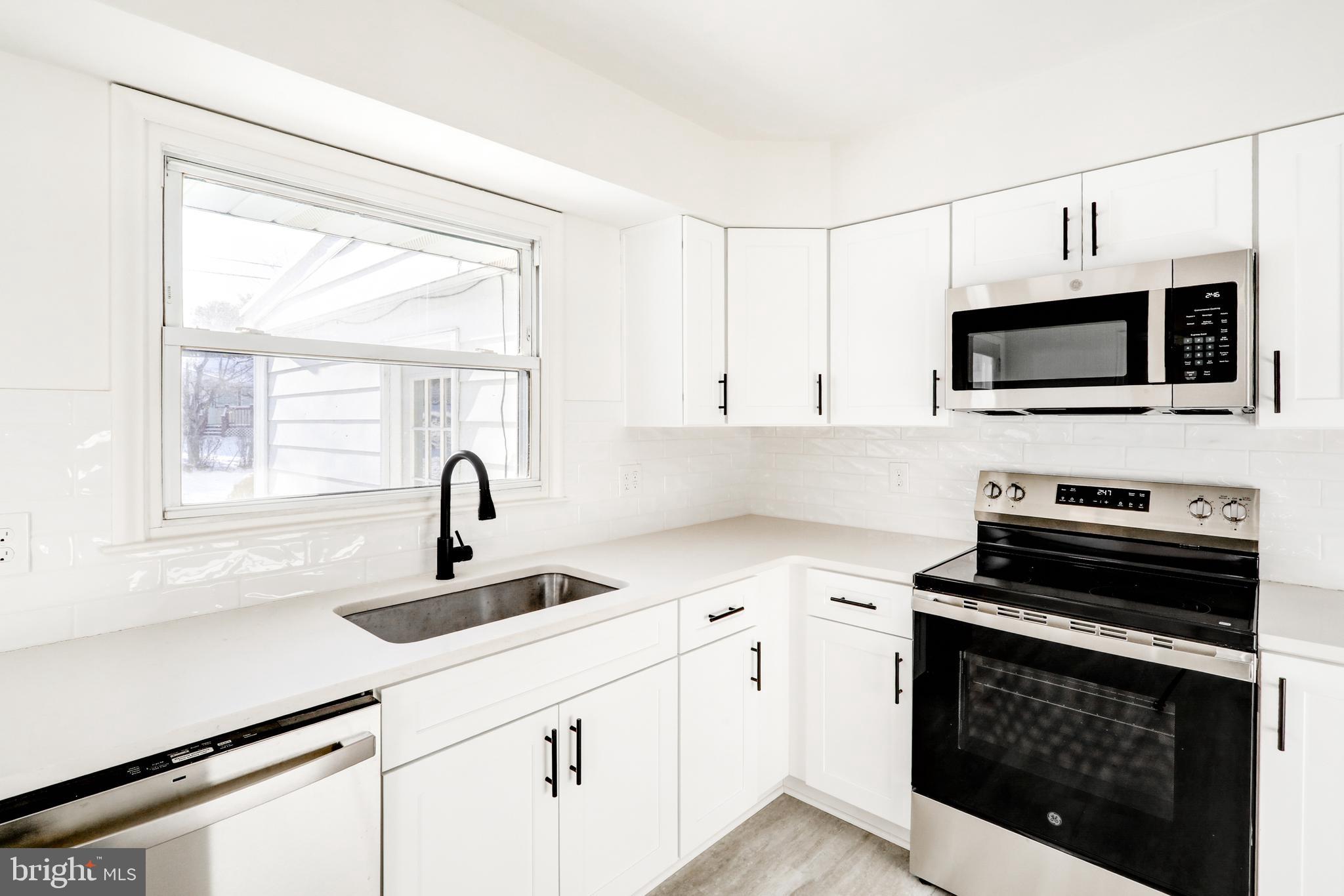 163 Thomas Place Reading, PA 19608 - Photo 12 of 36 a kitchen with a sink a stove and cabinets