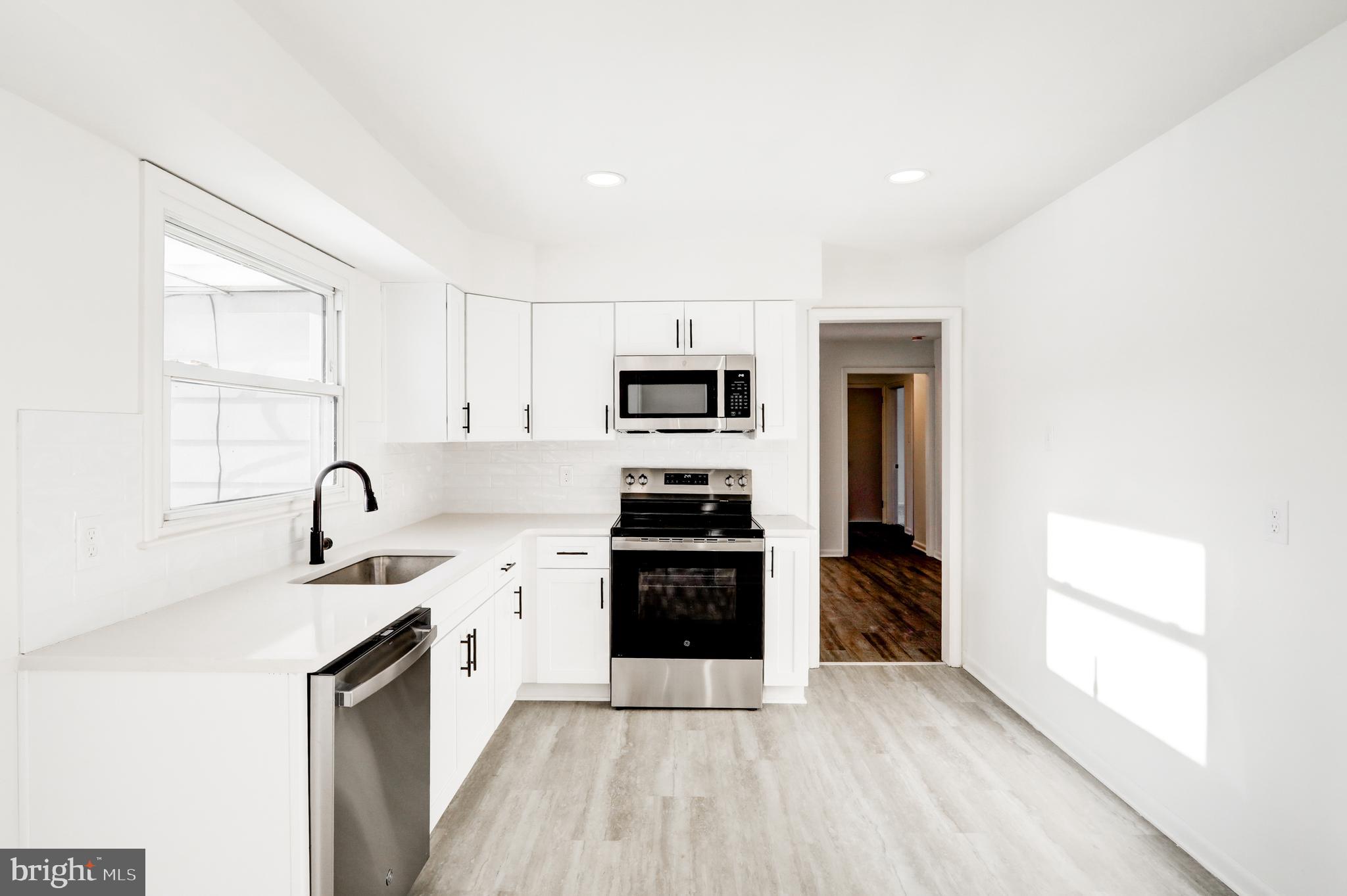163 Thomas Place Reading, PA 19608 - Photo 14 of 36 a kitchen with granite countertop a stove and a refrigerator