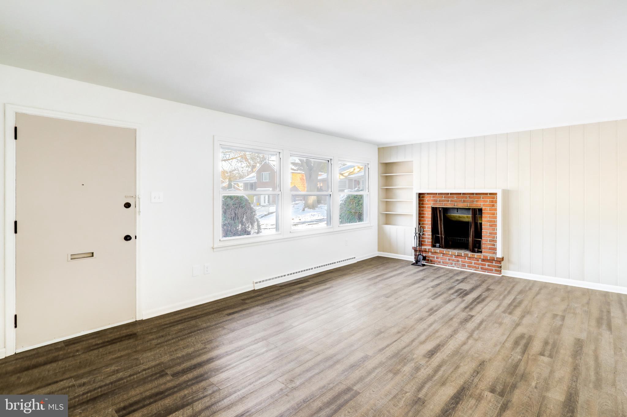 163 Thomas Place Reading, PA 19608 - Photo 2 of 36 an empty room with wooden floor fireplace and windows