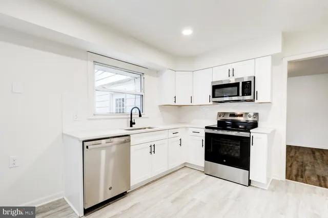 a kitchen with sink a microwave and cabinets