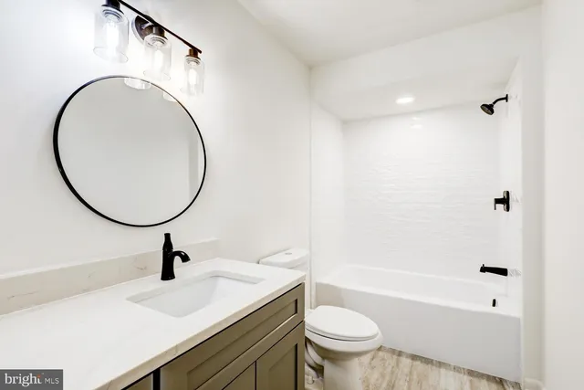 a bathroom with a sink a toilet and a mirror