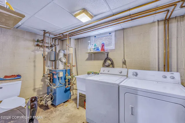 a utility room with stainless steel appliances a refrigerator and furniture