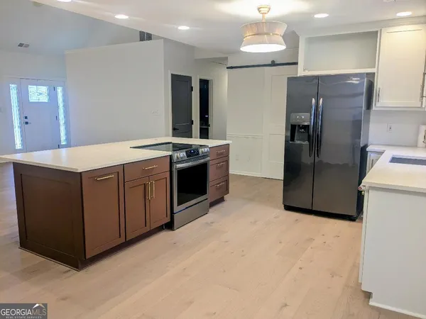 a kitchen with stainless steel appliances granite countertop a refrigerator a sink and a stove