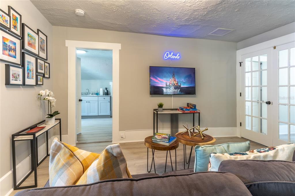 515 Daniels Avenue Orlando, FL 32801 - Photo 14 of 36 a living room with furniture a flat screen tv and a floor to ceiling window