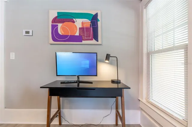 a view of a workspace with furniture and window