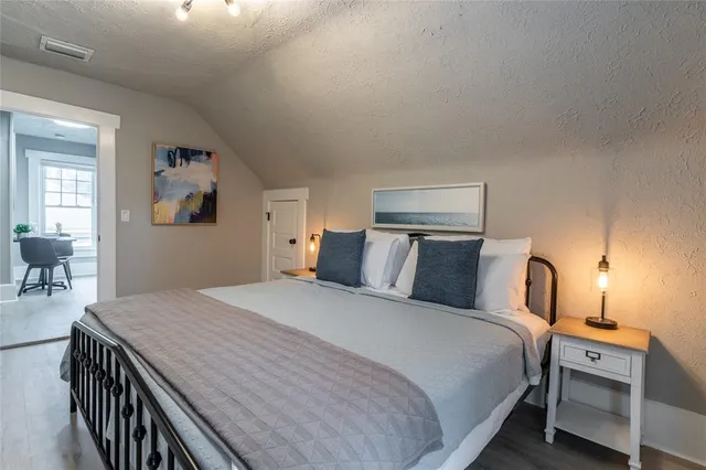 a bedroom with a bed and dresser with mirror