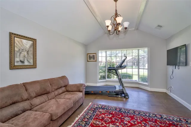 a living room with furniture a chandelier and a floor to ceiling window