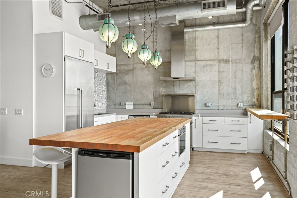 115 West 4th Street, Unit 203 Long Beach, CA 90802 - Photo 17 of 32 a kitchen with a wooden floor and cabinets