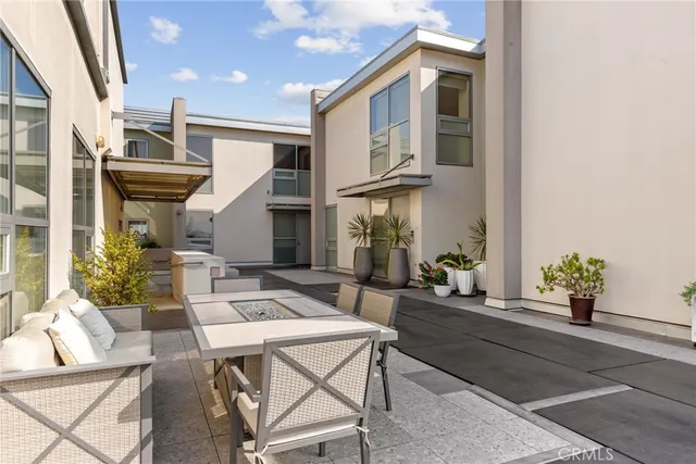 a view of a patio with couches table and chairs and potted plants