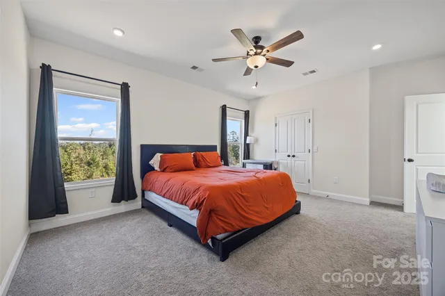 a spacious bedroom with a bed and a chandelier