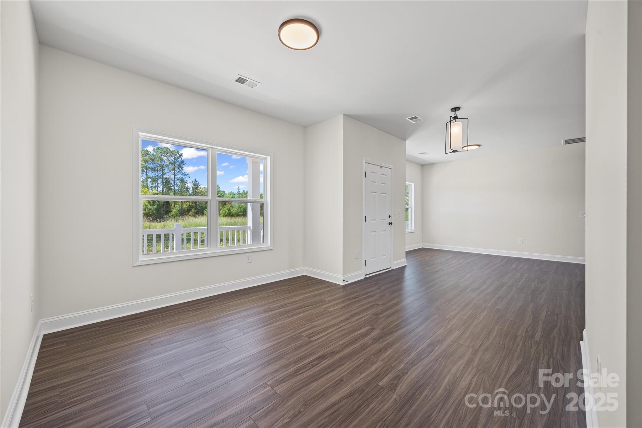 4822 Bull Run Road Blackstock, SC 29014 - Photo 4 of 34 an empty room with wooden floor and windows