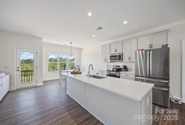 a kitchen with a sink stainless steel appliances a refrigerator and a stove