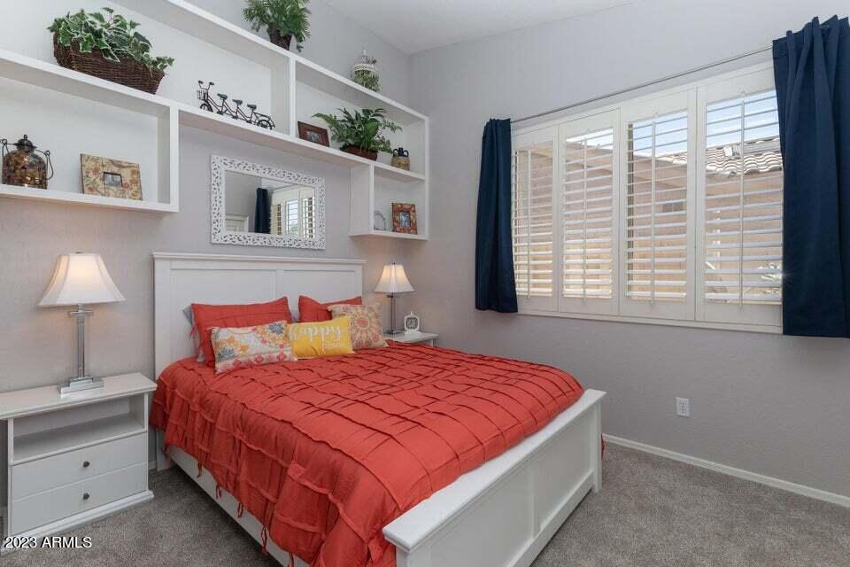 7338 East Wingspan Way Scottsdale, AZ 85255 - Photo 19 of 32 a bedroom with a large bed and a lamp on dresser