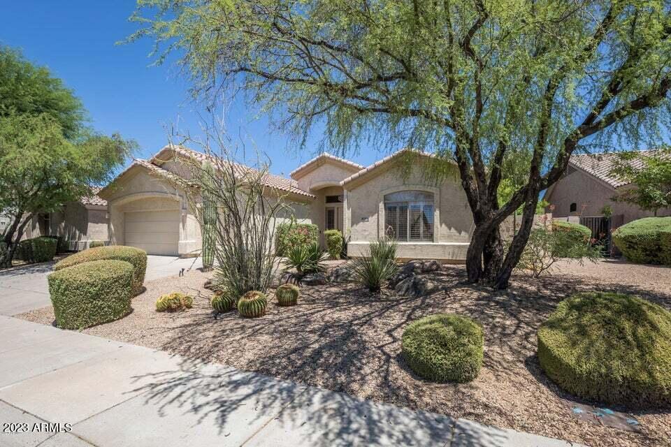 7338 East Wingspan Way Scottsdale, AZ 85255 - Photo 2 of 32 a front view of a house with a yard