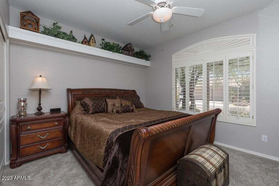 7338 East Wingspan Way Scottsdale, AZ 85255 - Photo 21 of 32 a bedroom with a bed and a chandelier