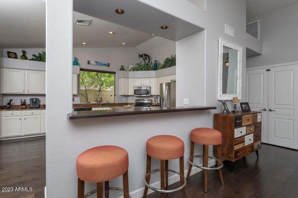7338 East Wingspan Way Scottsdale, AZ 85255 - Photo 8 of 32 a kitchen with stainless steel appliances a dining table chairs refrigerator and sink