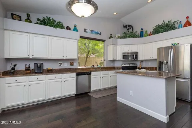 a kitchen with stainless steel appliances granite countertop a stove a sink and a refrigerator