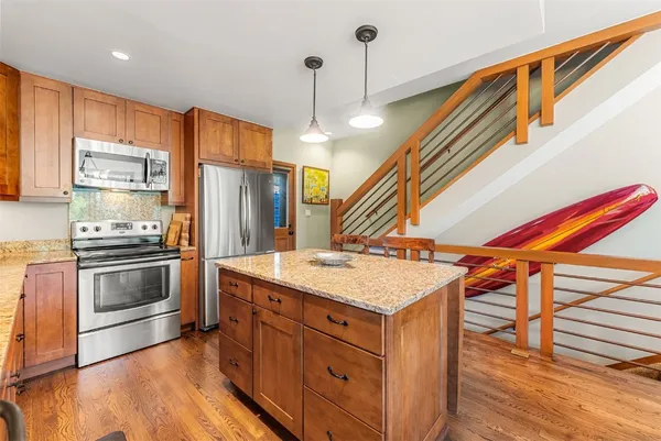 a kitchen with a sink a refrigerator and wooden floor