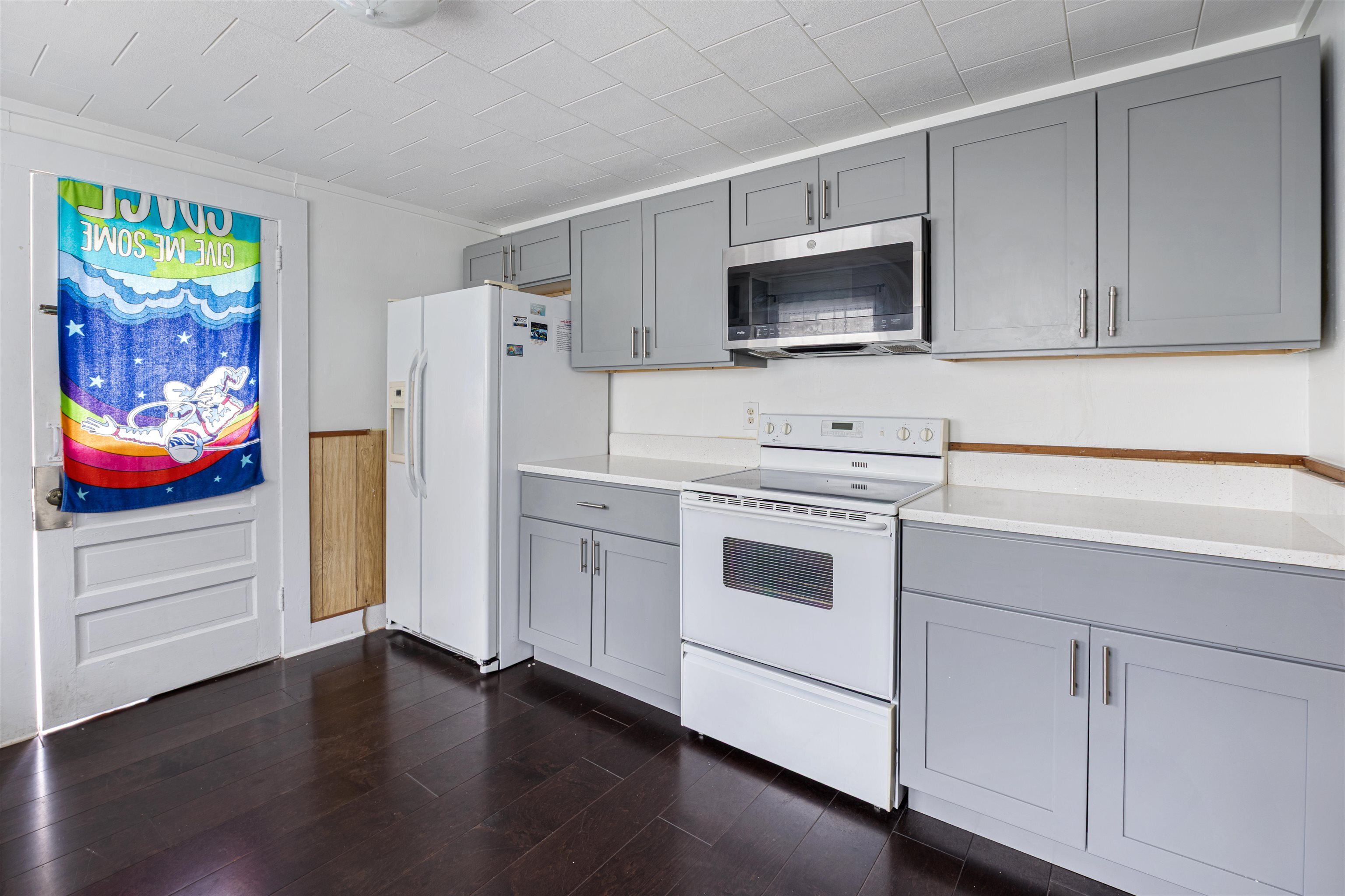 112 South Juniper Street Foley, AL 36535 - Photo 22 of 64 Kitchen with gray cabinets, white appliances, dark wood finished floors, and wainscoting