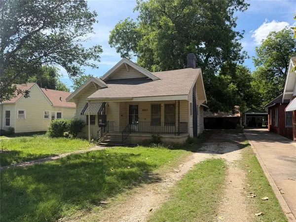 a front view of a house with a yard and trees