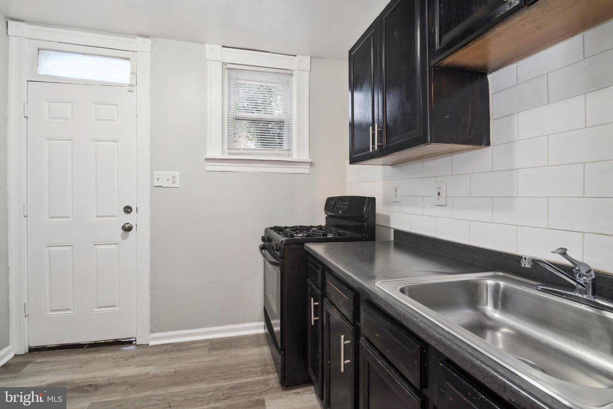 3020 Mathews Street Baltimore, MD 21218 - Photo 11 of 25 a kitchen with stainless steel appliances granite countertop a sink stove and cabinets