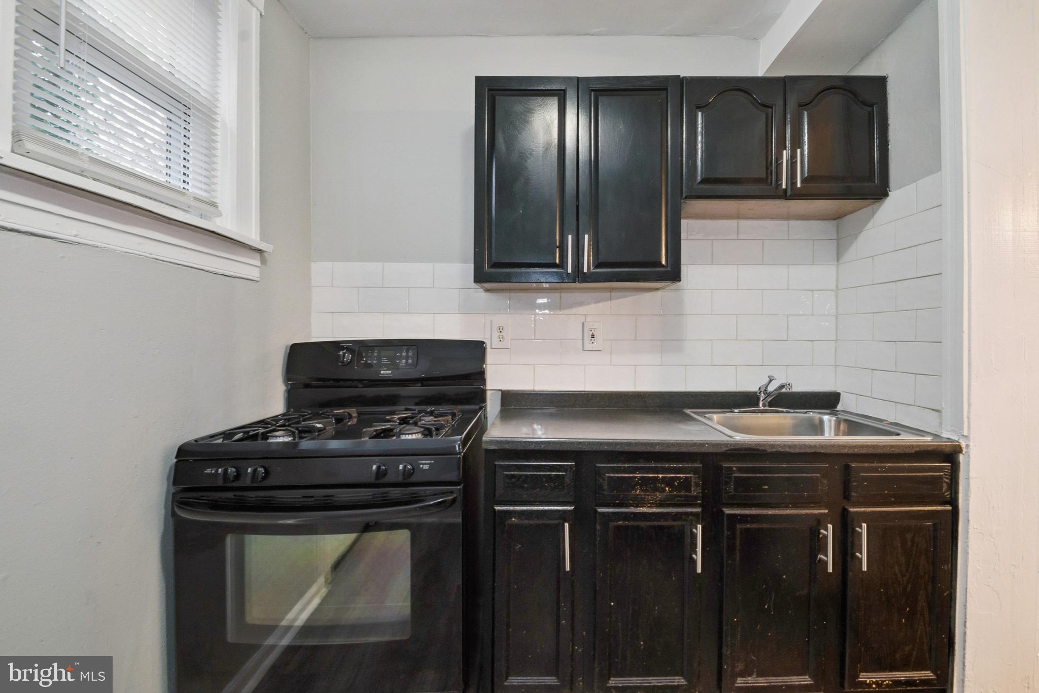 3020 Mathews Street Baltimore, MD 21218 - Photo 12 of 25 a kitchen with stainless steel appliances granite countertop a stove a sink and a microwave