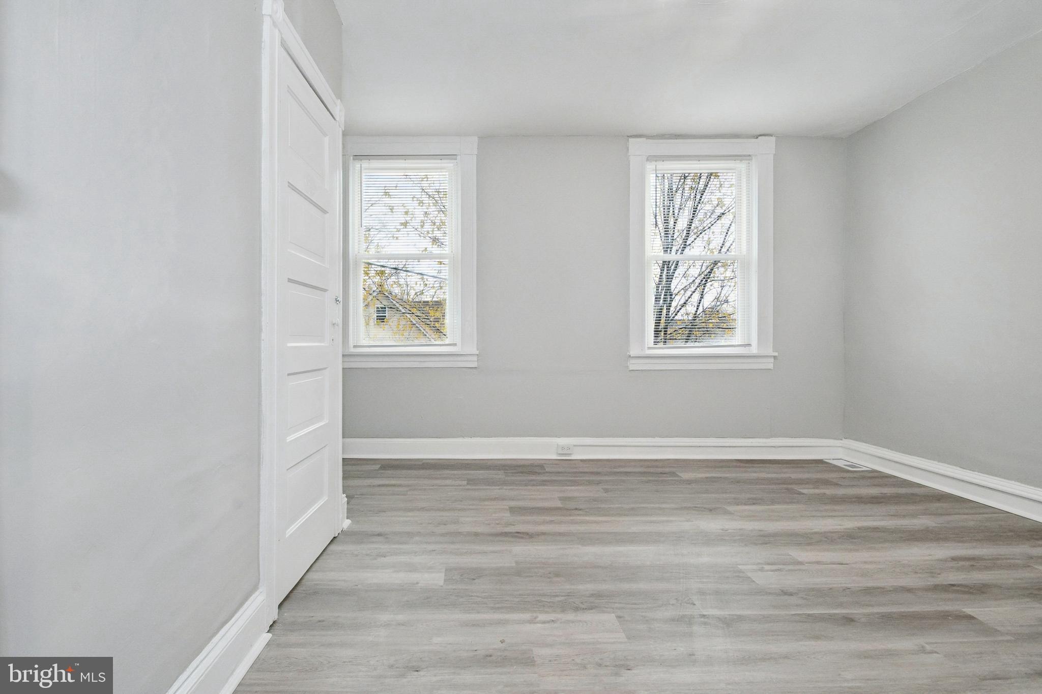 3020 Mathews Street Baltimore, MD 21218 - Photo 14 of 25 an empty room with wooden floor and windows