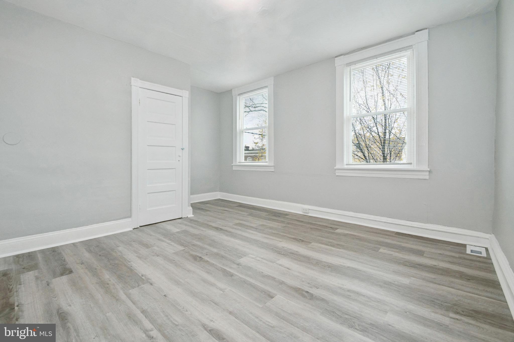 3020 Mathews Street Baltimore, MD 21218 - Photo 15 of 25 an empty room with wooden floor and windows