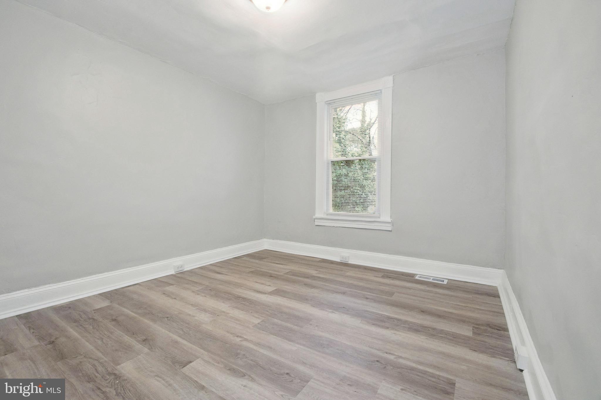 3020 Mathews Street Baltimore, MD 21218 - Photo 19 of 25 an empty room with wooden floor and windows