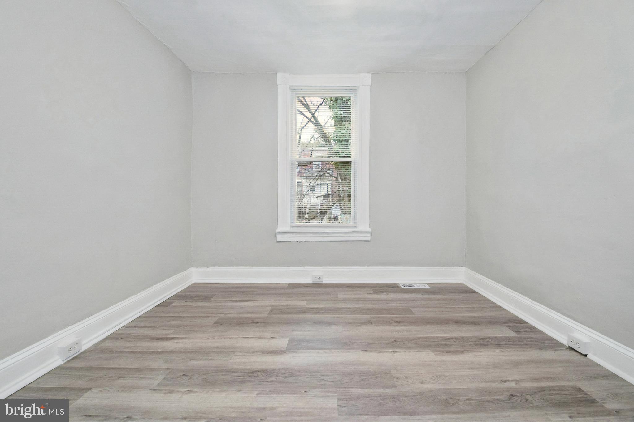3020 Mathews Street Baltimore, MD 21218 - Photo 20 of 25 a view of an empty room with wooden floor and a window
