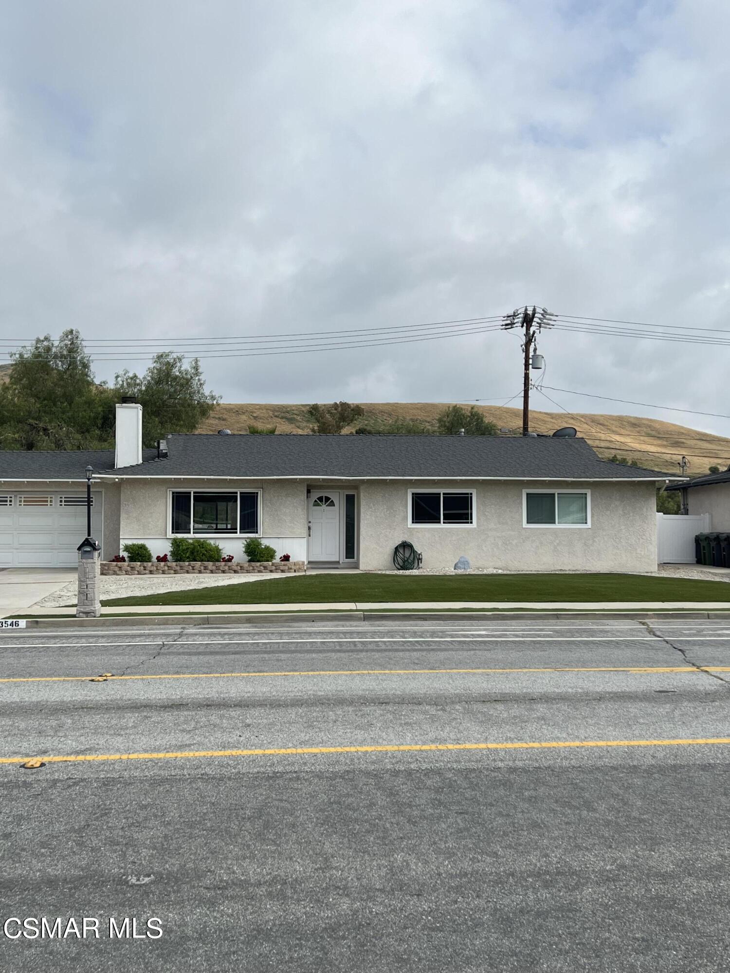 a view of a big house in middle of the road