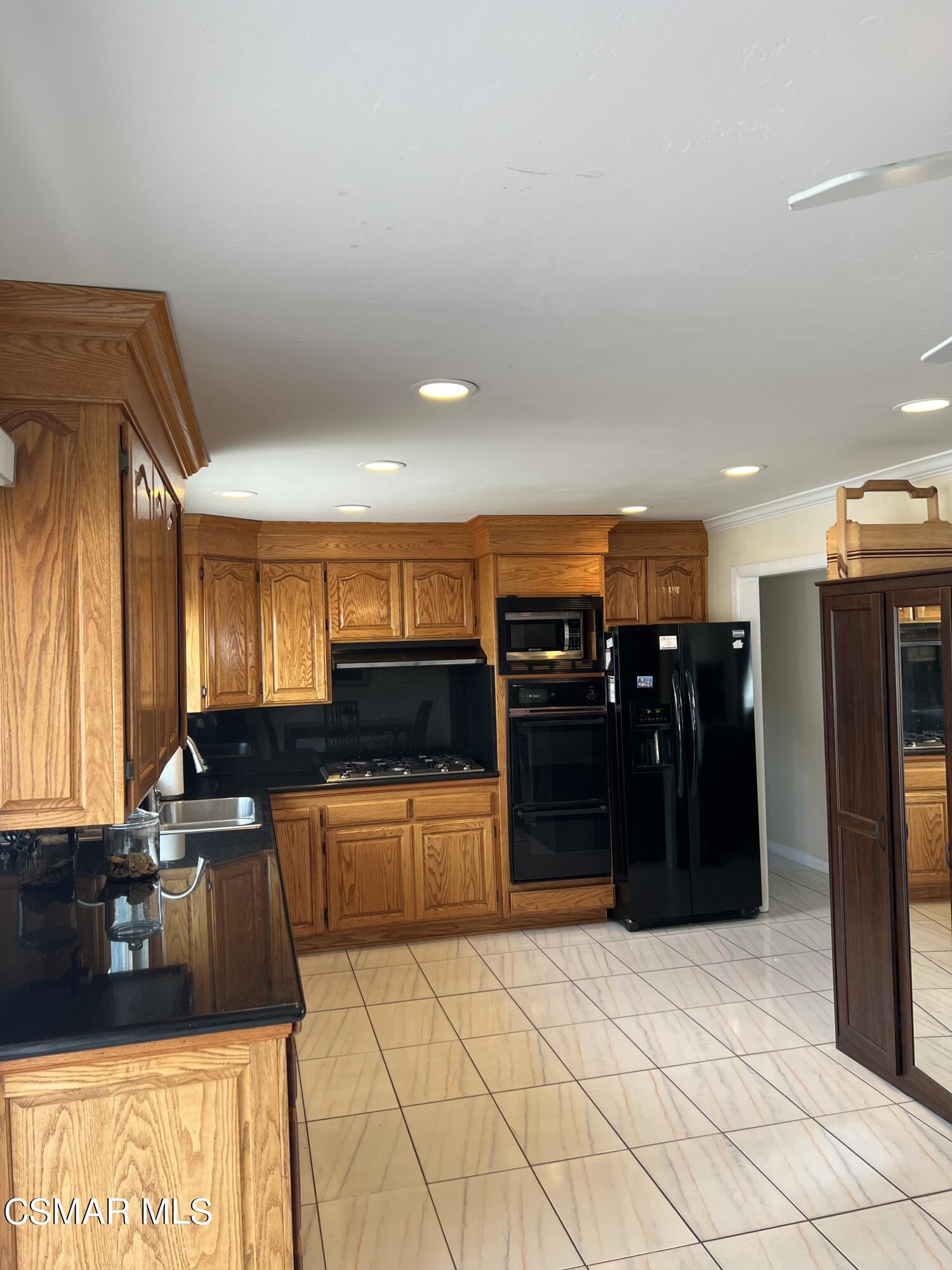 3546 Royal Avenue Simi Valley, CA 93063 - Photo 11 of 26 a kitchen with stainless steel appliances kitchen island granite countertop a refrigerator and a sink