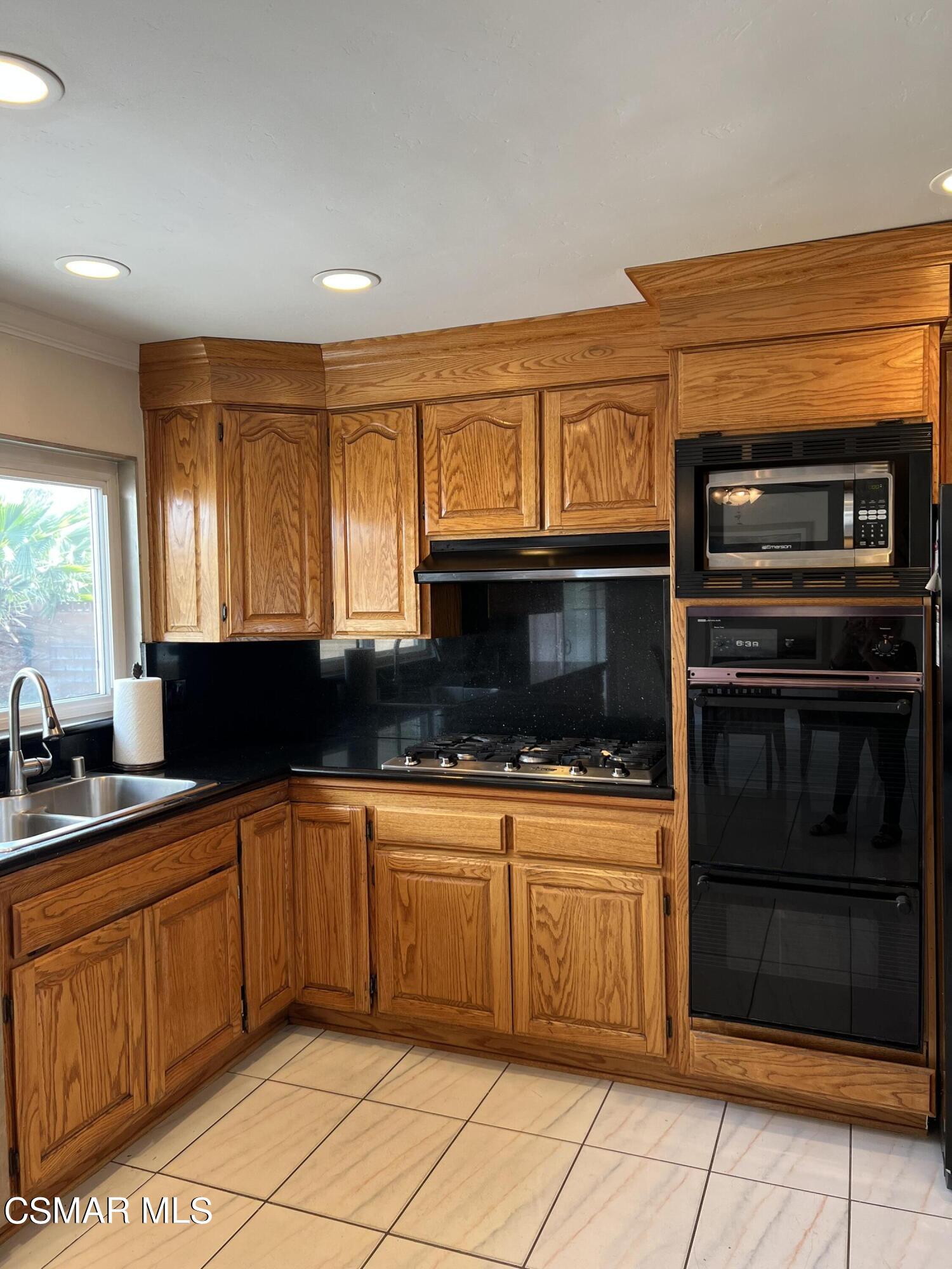 3546 Royal Avenue Simi Valley, CA 93063 - Photo 9 of 26 a kitchen with stainless steel appliances a stove sink and microwave