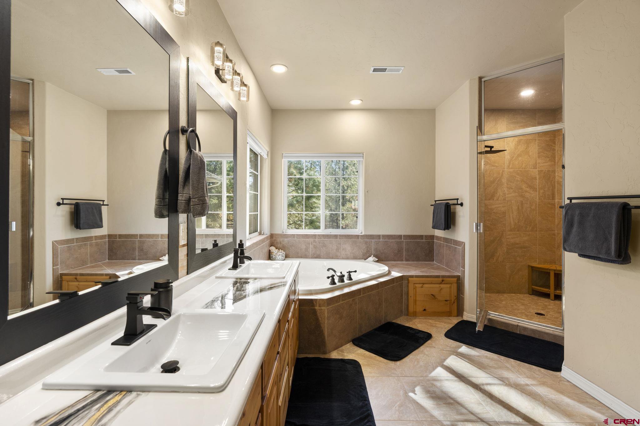 23 Hunter Court Durango, CO 81301 - Photo 25 of 42 a bathroom with a double vanity sink a mirror and a bathtub