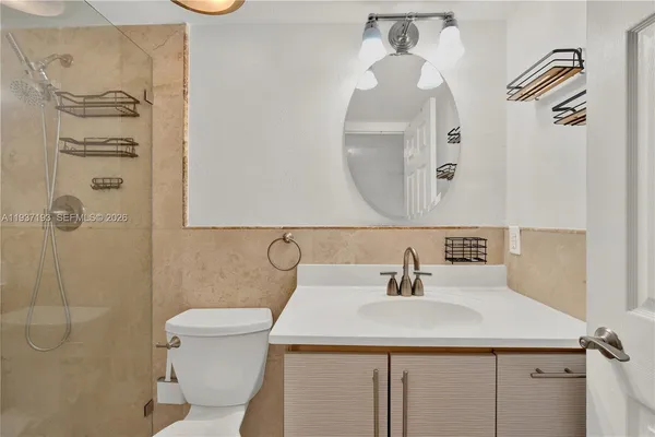 a bathroom with a sink a toilet and shower