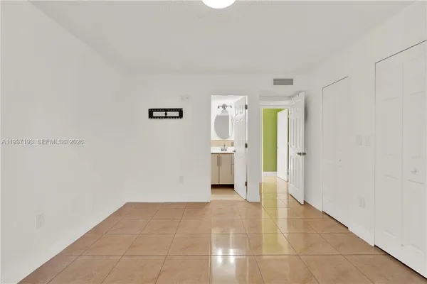 a view of a hallway with wooden cabinet and a bathroom