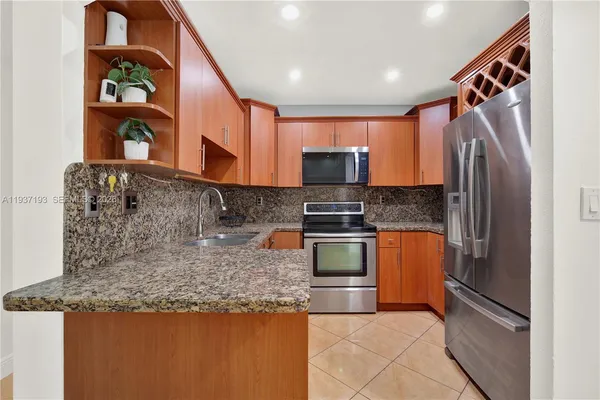 a kitchen with stainless steel appliances granite countertop a refrigerator and a stove
