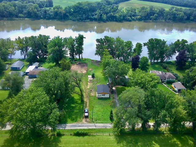 an aerial view of a house with a yard and lake view