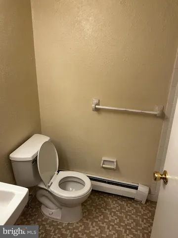 a white toilet sitting next to a shower
