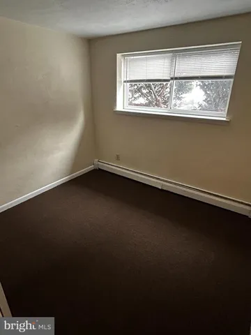 a view of a small space with wooden floor and a window