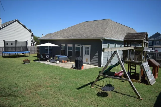 a view of a house with patio and a yard