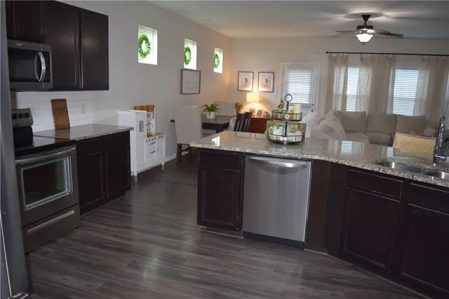 a kitchen with granite countertop a sink cabinets and stainless steel appliances
