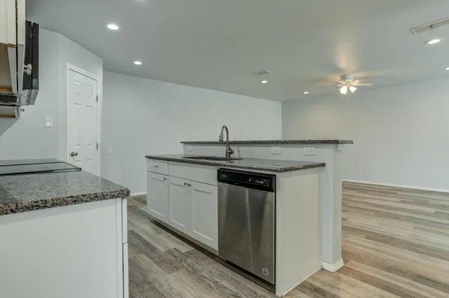a kitchen with a sink granite counter tops and a stove top oven