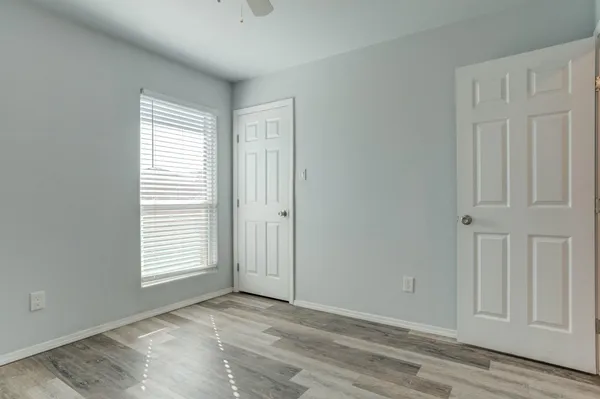 an empty room with wooden floor and windows