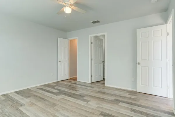 a view of a livingroom with a ceiling fan & hardwood floor