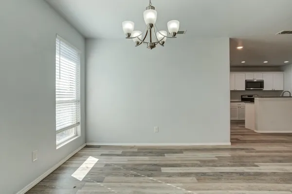 a view of a room with wooden floor and chandelier
