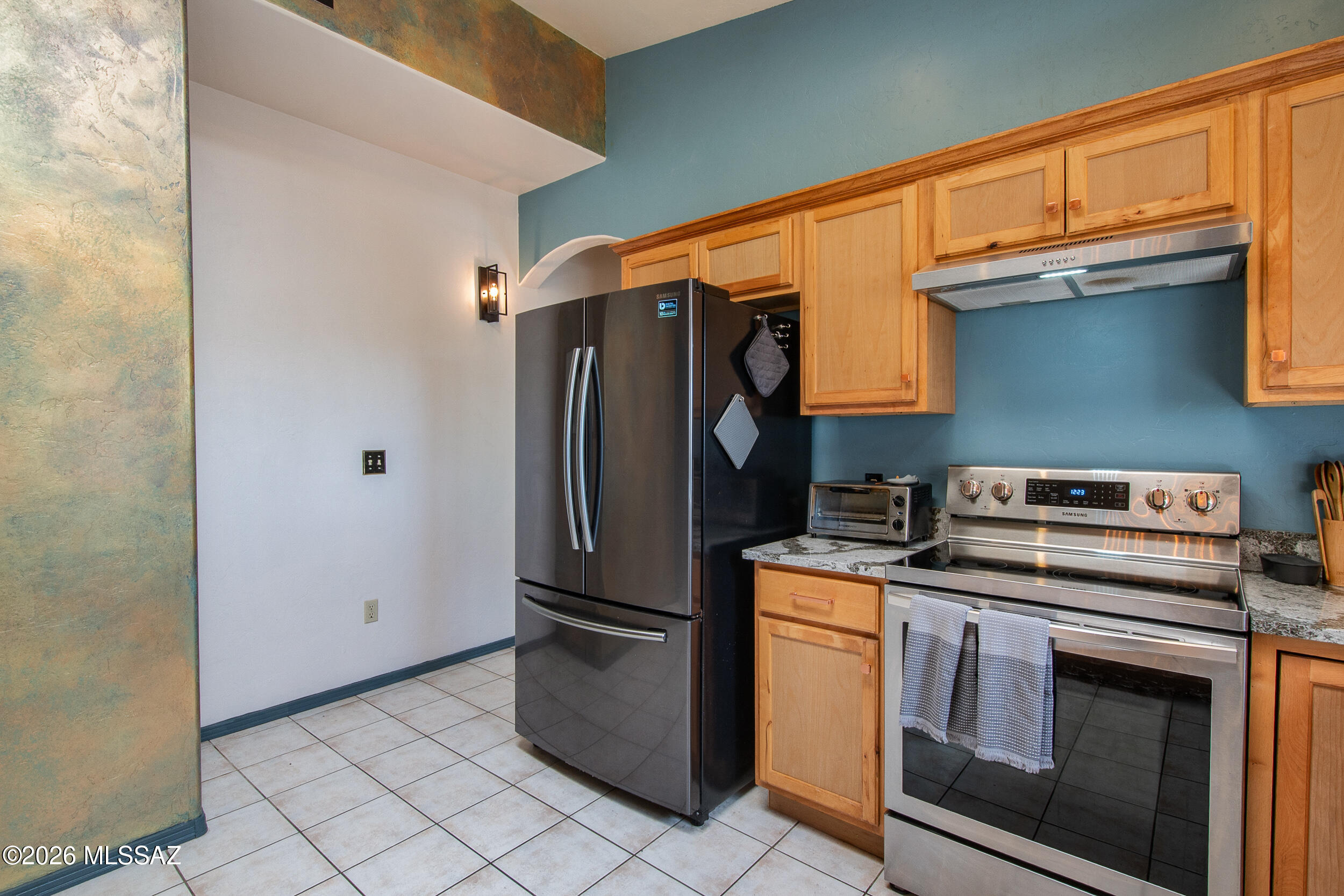 4155 West Coyote Ridge Trail Tucson, AZ 85746 - Photo 24 of 39 a kitchen with stainless steel appliances granite countertop a refrigerator and a stove