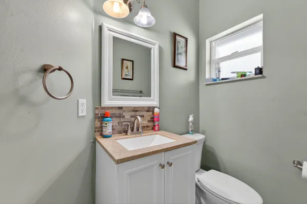 a bathroom with a toilet sink and mirror