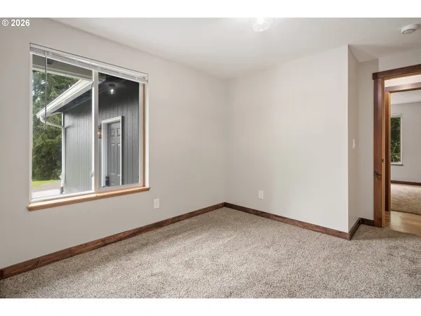 a view of an empty room with closet and a window